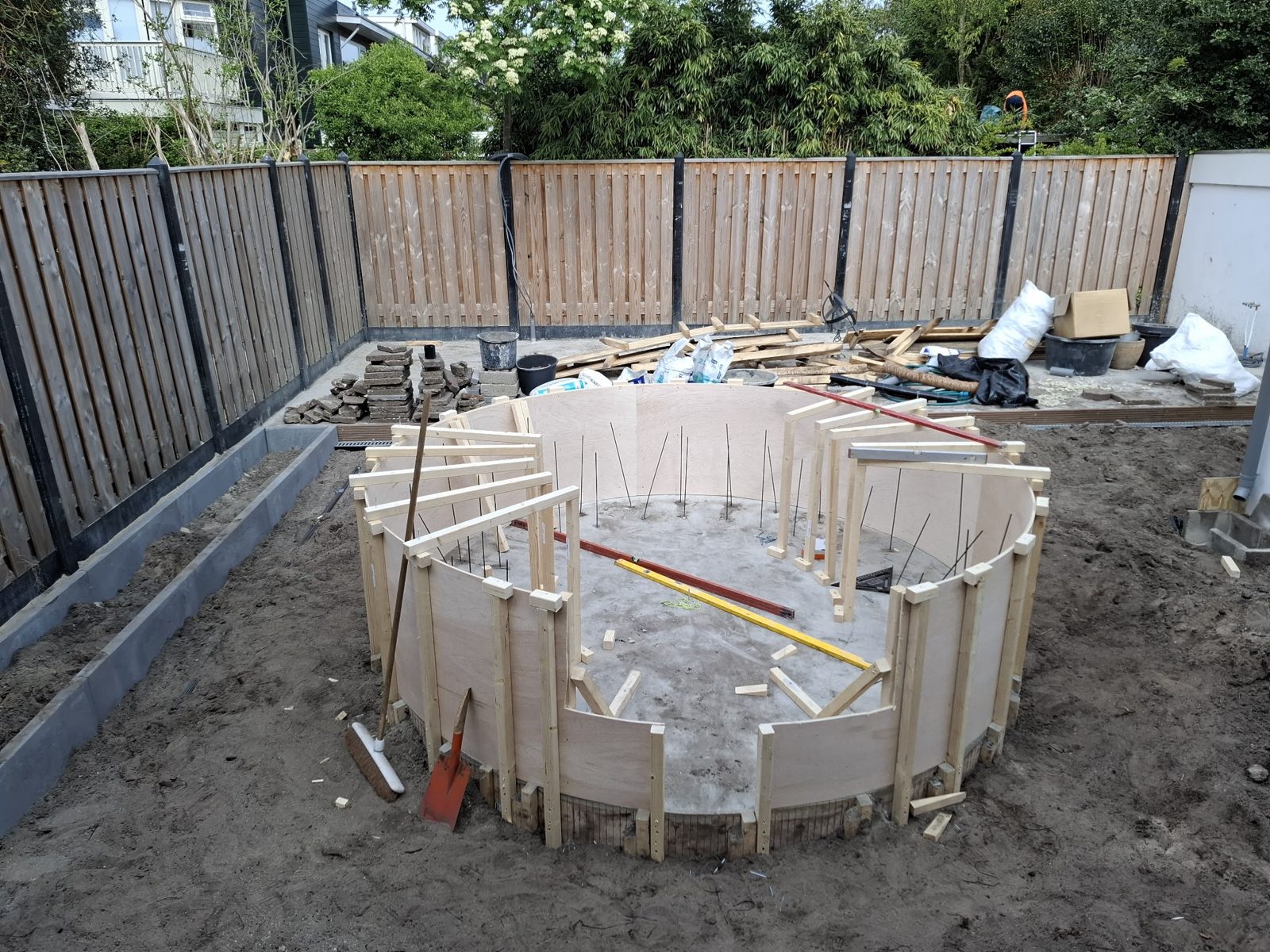 Tijdens de bouw: gebogen houten bekisting voor de ronde zitkuil in dezelfde tuin